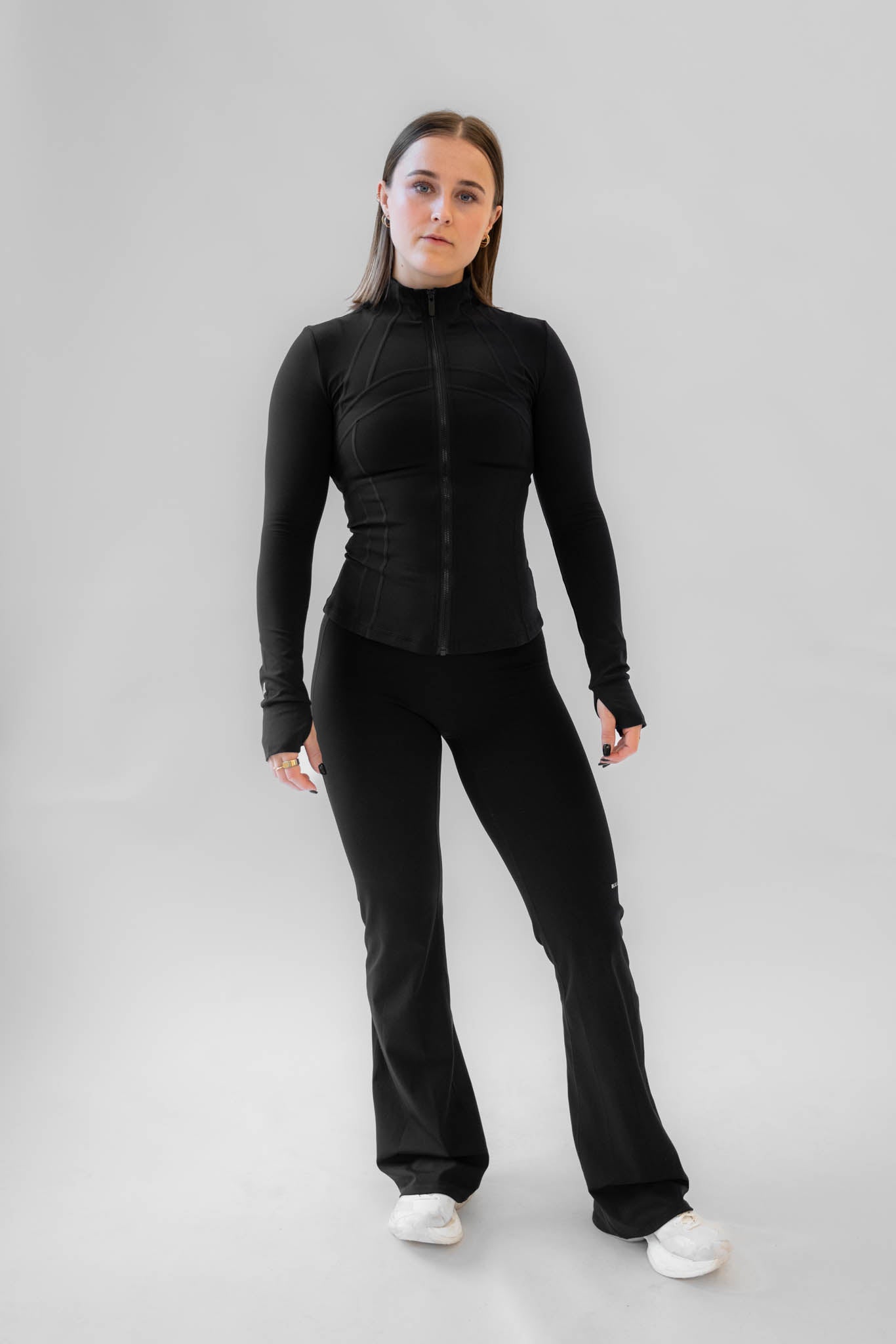 Model iført sort SCULPT Bundle med fitted zip jacket og flare pants.